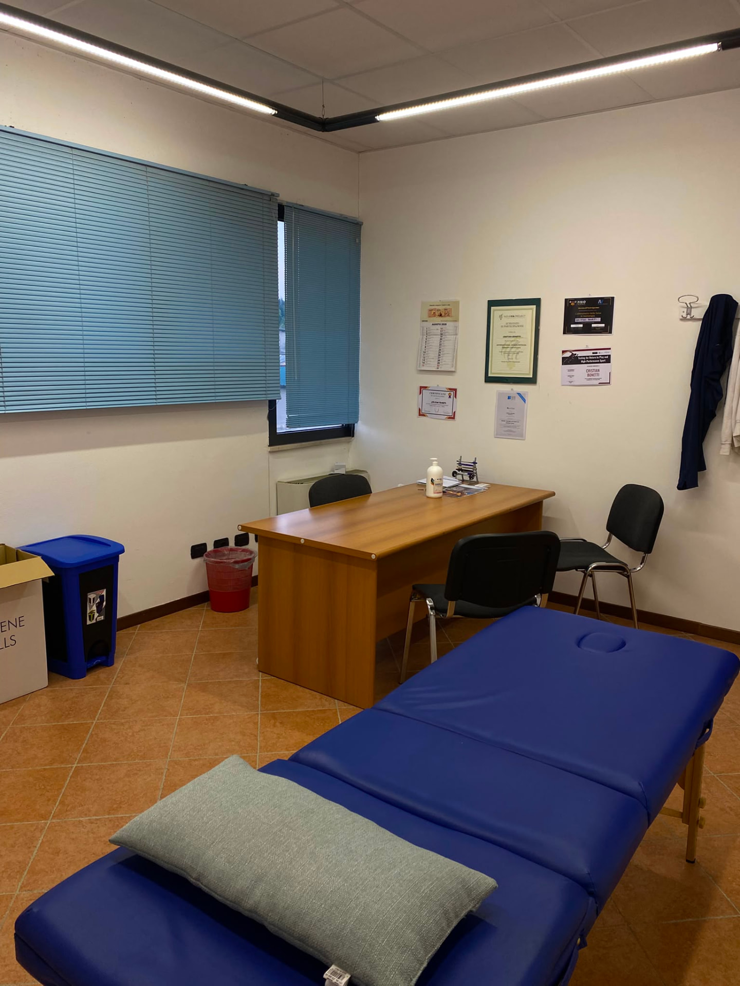 Sala trattamenti dello studio: lettino, scrivania e attestati appesi alla parete